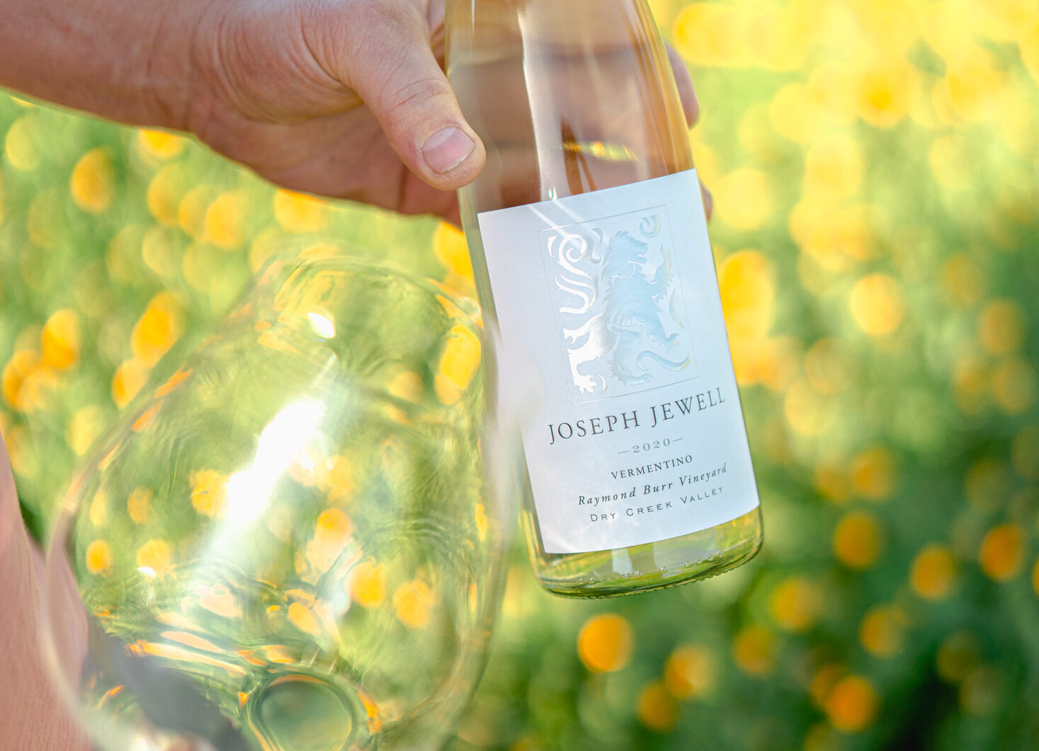 Joseph Jewell Wines owner and winemaker, Adrian Jewell Manspeaker, holding a bottle of 2020 Joseph Jewell Vermentino from the Raymond Burr Vineyard in Dry Creek Valley, Sonoma County